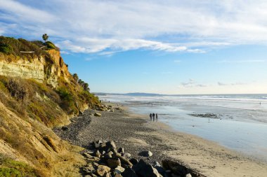 Mavi gökyüzü ve beyaz bulutlar ile kayalığın yanında beautiul Plajı. San Elijo State Beach, Encinitas, San Diego, Kaliforniya.