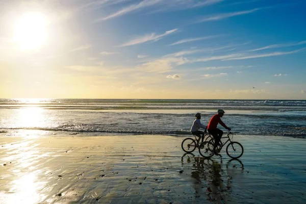 Sylwetka Ludzi Korzystających Rowerowych Plaży Spokojnym Momencie Zachodu Słońca Piękne — Zdjęcie stockowe