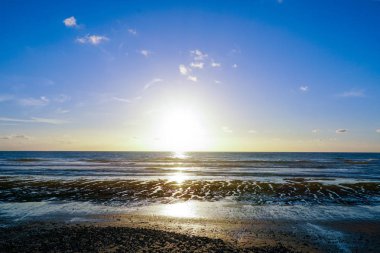 Deniz üzerinde güzel renkli günbatımı, alacakaranlık zaman güzel gökyüzü ve denizde yansıma.