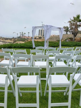 Okyanus önünde bahçede beyaz sandalyeler ve kemer ile düğün töreni ayarı, düğün konsepti, La Jolla, Kaliforniya, ABD