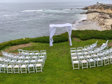 Okyanus önünde bahçede beyaz sandalyeler ve kemer ile düğün töreni ayarı, düğün konsepti, La Jolla, Kaliforniya, ABD