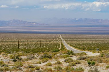 Joshua Tree Park'ın yanındaki sonsuz çöl düz yolu. Abd. Arizona yönüne doğru çöle doğru giden uzun düz asfalt yol.