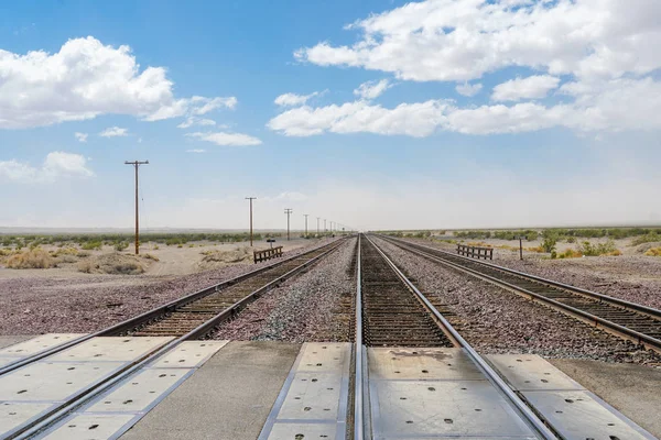 Railroad crossing gates on a road in the Mojave Desert in the Southwestern United States. California.