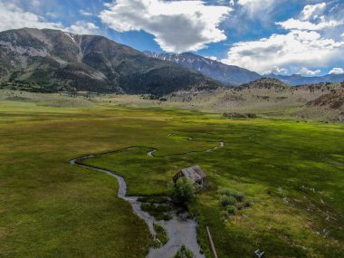 Bir dağın yeşil vadisinde terk edilmiş küçük ahşap ev ahır sonraki küçük nehir havadan görünümü, Aspen Spring, mono County, Kaliforniya, ABD. 