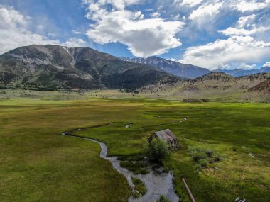 Bir dağın yeşil vadisinde terk edilmiş küçük ahşap ev ahır sonraki küçük nehir havadan görünümü, Aspen Spring, mono County, Kaliforniya, ABD. 