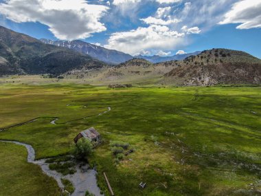 Bir dağın yeşil vadisinde terk edilmiş küçük ahşap ev ahır sonraki küçük nehir havadan görünümü, Aspen Spring, mono County, Kaliforniya, ABD. 