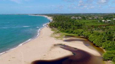 Tropikal beyaz kum plaj ve turkuaz birleştirme Nehri'nin hava üstten görünüm deniz suyu küçük dalgalar ile temizleyin ve palmiye ağaçları arka plan. Praia Forte, Bahia, Brezilya var. Seyahat tropikal kavramı