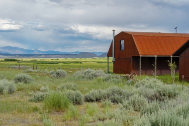 Kırmızı çiftlik arka planda dağ ile büyük bir otlak çiftlik alanında döken. Doğu Sierra Dağları, Mono County, Kaliforniya, Amerika Birleşik Devletleri