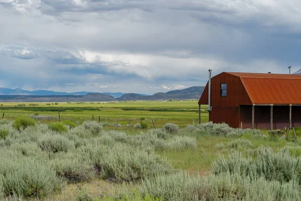 Kırmızı çiftlik arka planda dağ ile büyük bir otlak çiftlik alanında döken. Doğu Sierra Dağları, Mono County, Kaliforniya, Amerika Birleşik Devletleri
