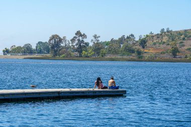 Arkadaşlar mutluluk. Yong kızlar ahşap iskelede oturan ve bir dinlenme zaman yaşıyorsanız. Miramare Gölü, San Diego, Kaliforniya, Amerika Birleşik Devletleri.