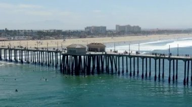 Huntington İskelesi'nin havadan görünümü, güneşli yaz günlerinde sahil ve sahil şeridi, Los Angeles'ın güneydoğusu. California. sörfçü ve turist için hedef.