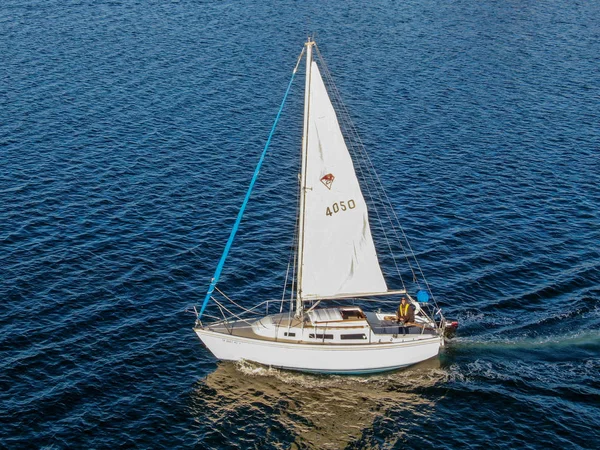 Aerial view of small sail boat in the Mission Bay of San Diego, California, USA. Small sailing ship yachts with white sails on calm water.