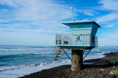 San Diego County bulunan Kaliforniya Torrey Pines State Beach, günün bulutlu mavi gökyüzü güneşli sonu ile kayalık bir kum plajda Mavi cankurtaran kulesi sayısı 4.