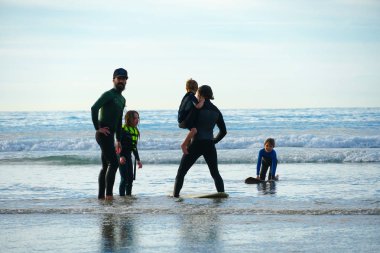 Baba ya da eğitmen küçük çocuğa denizde sörf yapmayı öğretiyor. Çocuk konsepti ile seyahat ve spor. Çocuklar için sörf dersi. Kaliforniya, San Diego, La Jolla Beach, Amerika Birleşik Devletleri.