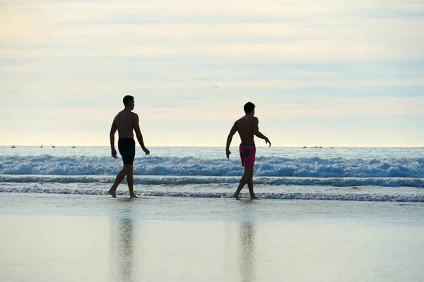 Δύο Νεαροί Άντρες Που Απολαμβάνουν Και Περπατούν Στη Θάλασσα Κατά — Φωτογραφία Αρχείου