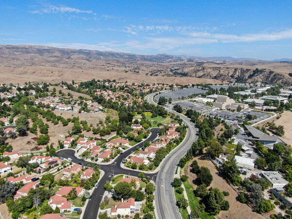 Aerial view of small neighborhood with dry desert mountain on the background in Moorpark, Ventura County in Southern California. USA