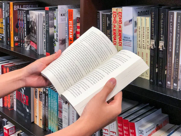 Hände halten ein Buch in der Buchhandlung. — Stockfoto