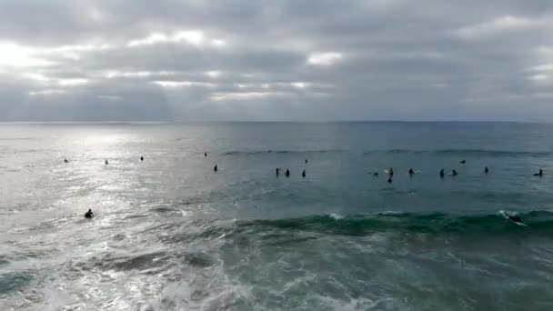 Vista aérea de surfistas esperando, remando y disfrutando de las olas — Vídeo de stock