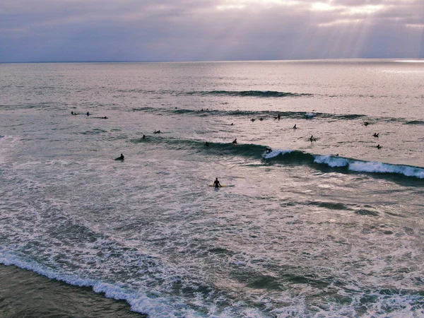Aerial view of surfers waiting waves before sunset — Stock Photo, Image