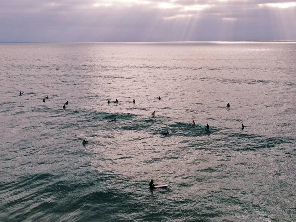 Vue aérienne des surfeurs attendant les vagues avant le coucher du soleil — Photo