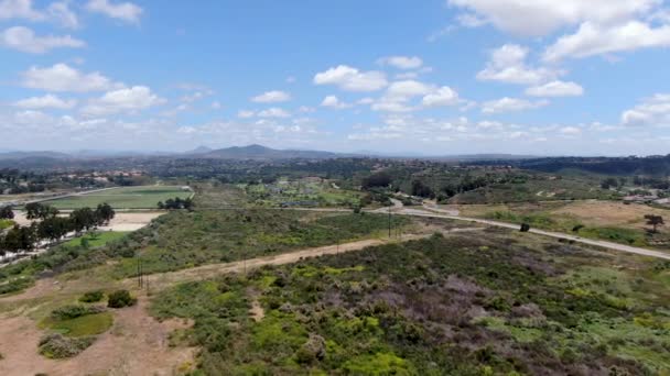 Luftaufnahme eines grünen Tals mit Golfplatz im Hintergrund in Südkalifornien — Stockvideo