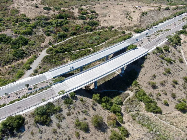 Letecký pohled na silniční most, viadukt podporuje v údolí mezi suchými kopci Yelllow — Stock fotografie