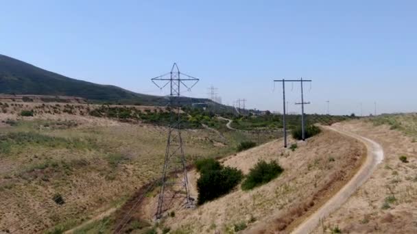 Вид с воздуха на пилон передачи электроэнергии в сухой долине пейзажа — стоковое видео