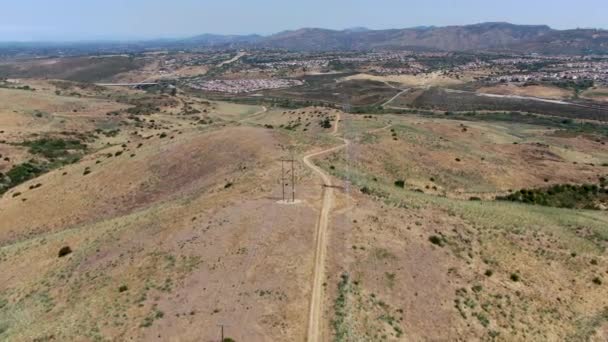 Luchtfoto van de elektriciteitstransmissie pyloon in droge vallei landschap — Stockvideo