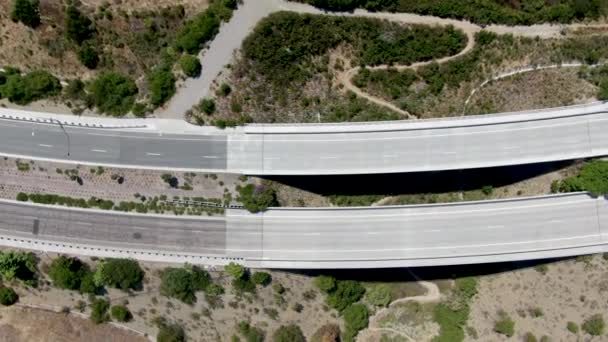 Vista aérea de la parte superior del puente de carretera, viaducto apoya en el valle entre las colinas de color amarillo seco — Vídeo de stock