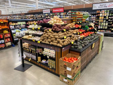 Meyve ve sebze çeşitleriyle dolu rafları olan bir süpermarketin iç manzarası
