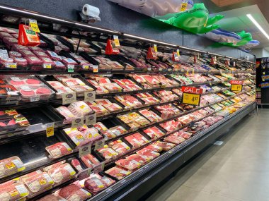 İçi et dolu kasap reyonuyla dolu bir süpermarketin iç manzarası.