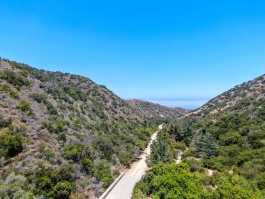 Santa Catalina Adası dağlarının ve arka planda okyanus olan patikaların havadan görünüşü