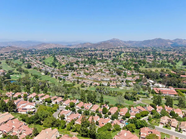 stock image Aerial view of residential neighborhood surrounded by golf in green valley