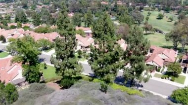 Yeşil vadide golfle çevrili yerleşim yerlerinin hava manzarası