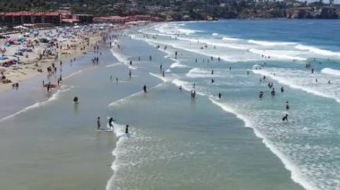 Plajın ve La Jolla Körfezi 'ndeki küçük dalgaların tadını çıkaran turistlerin hava manzarası.