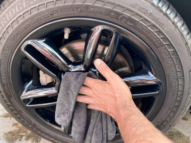 Mans el temizliği siyah mikrofiber bez ile araba. Arabanın yüzeyi elle silinmiş.