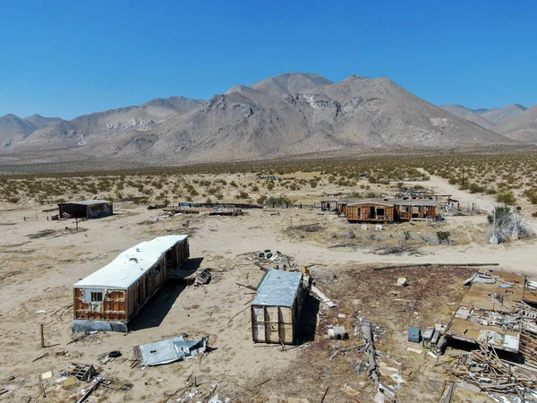 Vista aérea de casas abandonadas e trailer de campista no meio do deserto — Fotografia de Stock