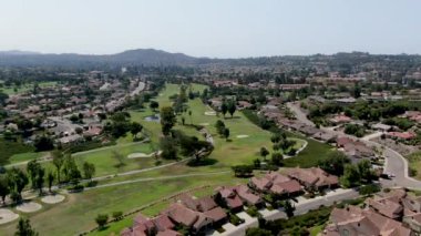 Orta sınıf bir mahalledeki golfün havadan görünüşü Güney Kaliforniya 'daki konut eviyle çevrili.
