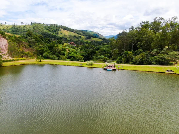 Vista aérea de la cabaña de madera al lado del lago en el valle, con la familia disfrutando de momentos de relax —  Fotos de Stock