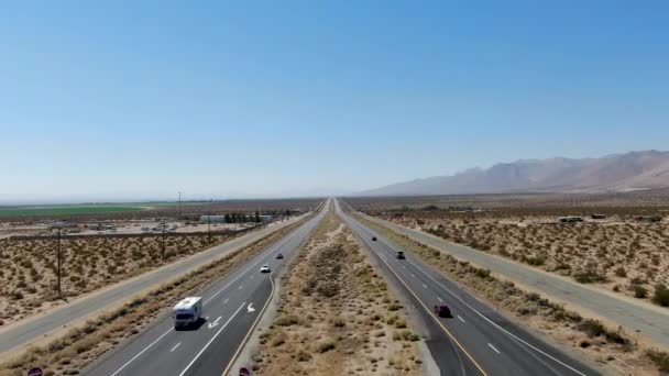 캘리포니아 사막의 푸른 하늘 아래 사막 한 가운데있는 도로를 공중에서 내려다본 모습 — 비디오