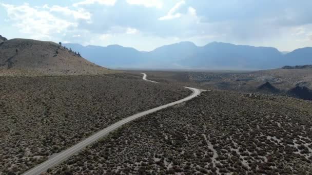 먼지투성이의 건조 한 사막 지대에 있는 아스팔트 도로를 공중에서 내려다본 모습 — 비디오