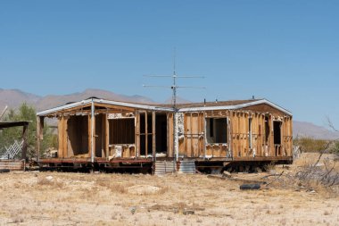 Terk edilmiş evler ve çölün ortasında bir karavan.