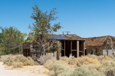 Terk edilmiş evler ve çölün ortasında bir karavan.