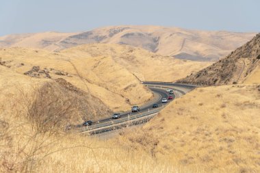 Kurak ve sıcak mevsimde San Luis Reservoir vadilerinden geçen çevre yolu, Kaliforniya, ABD