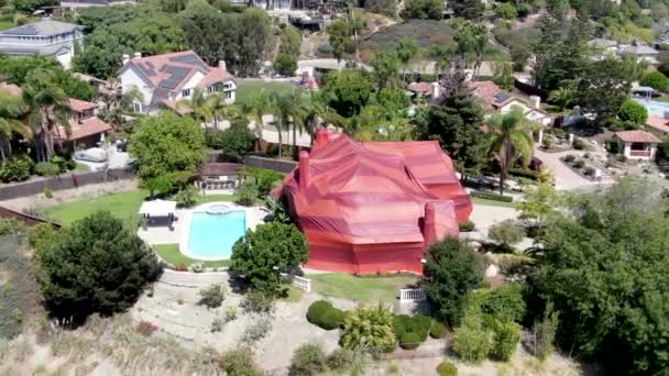 Vista aérea de villa residencial cubierta con una carpa roja mientras se fumigaba para termitas. — Vídeos de Stock