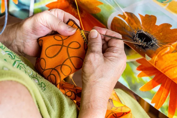 Yaşlı kadın bir tığ işi tepsi işlemeli
