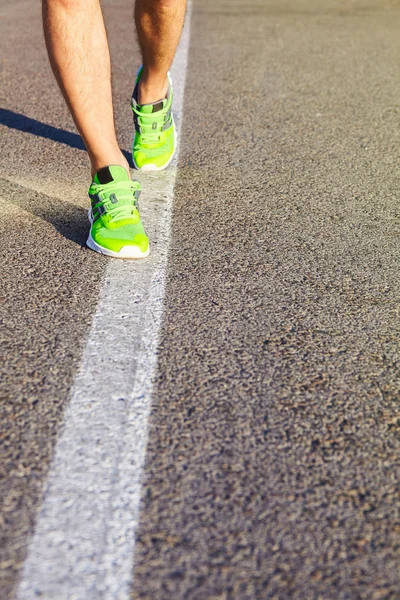 Runner man feet running on road closeup on shoe. Male fitness athlete jogger workout in wellness concept. Male athletes in running shoes. Jogging