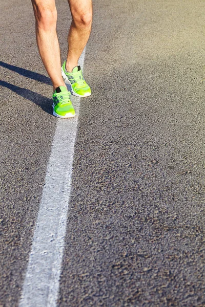 Runner man feet running on road closeup on shoe. Male fitness athlete jogger workout in wellness concept. Male athletes in running shoes. Jogging