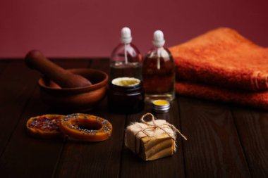 Koyu ahşap arka plan olarak el yapımı Sabun Bar. Doğal kozmetik yağ, krema ve eflatun koyu arka plan üzerinde doğal el yapımı mum. Sağlıklı cilt bakımı. Aromaterapi, spa ve sağlıklı yaşam konsepti