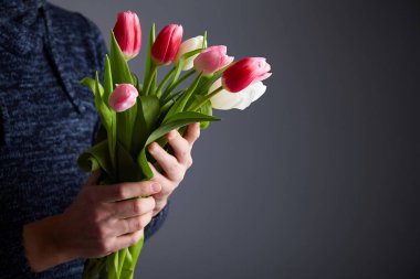 Lale erkek holding grup. Renkli lale adamın elinde. Stüdyo ışık. Yumuşak odak. Bahar çiçek, pembe, beyaz ve lale elinde. Paskalya, Doğum günü, Anne, kadın, düğün günü kavramı.